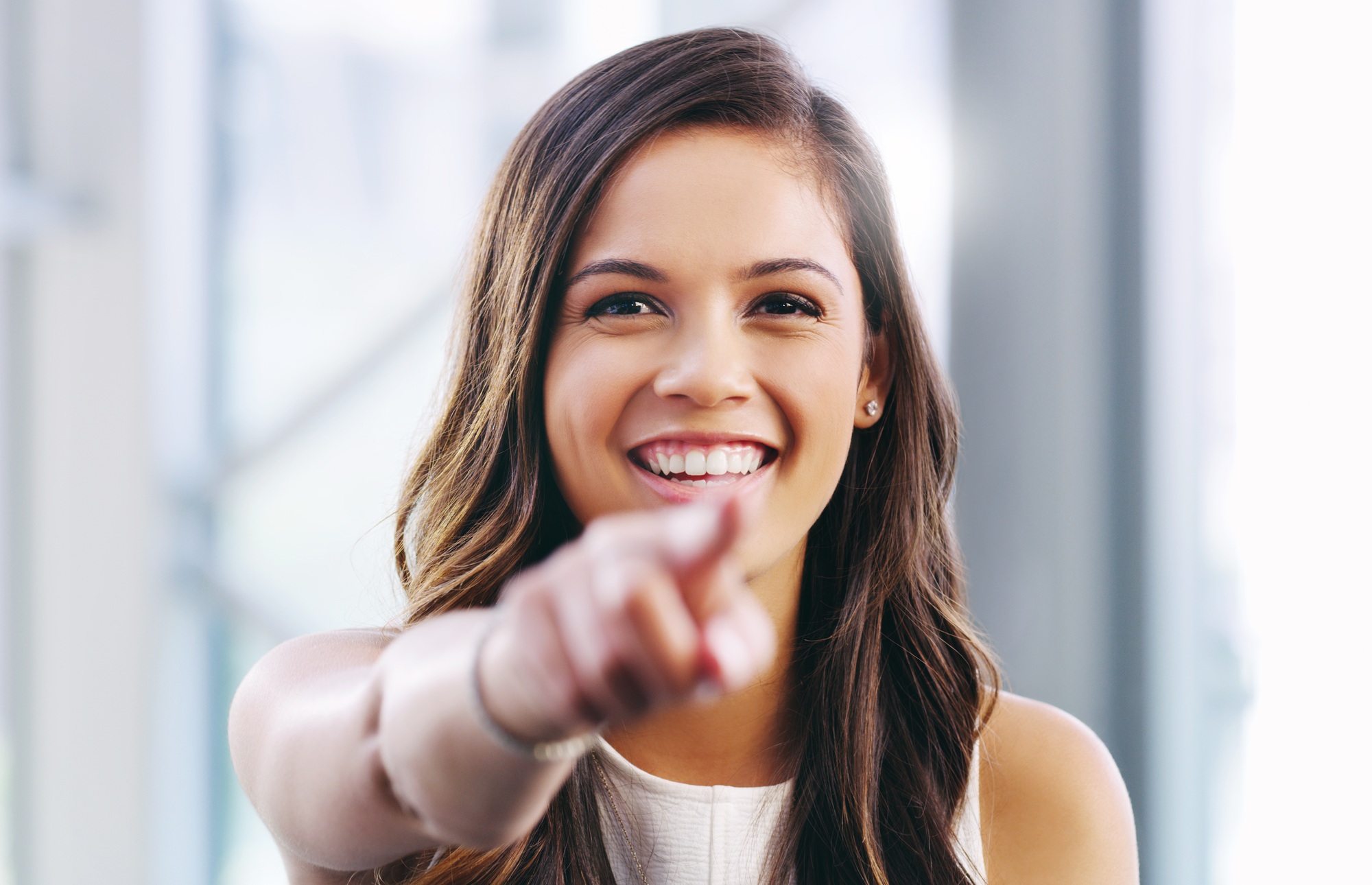 Portrait of a confident young businesswoman pointing at you in a modern office